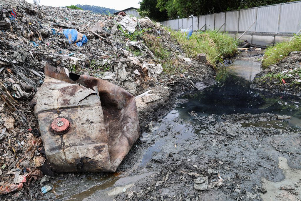 กองเก็บกากของเสียจากกระบวนการผลิตไว้ภายนออกโรงงานในพื้นที่โล่งแจ้ง